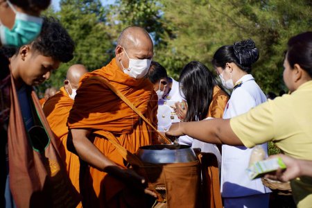 Photo for Give food offerings to a Buddhist monk On the occasion of Thai Father's Day , 5 December 2023 , Buriram Thailand. - Royalty Free Image