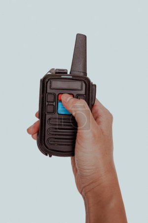 Right hand holds a walkie talkie radio communication on white isolated background.