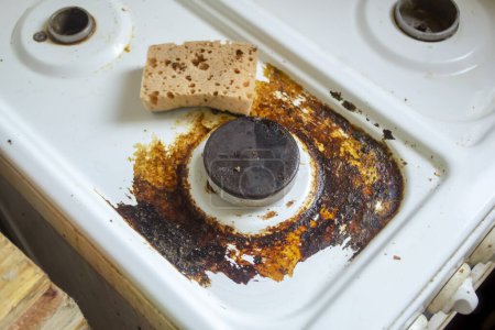 Téléchargez les photos : Cuisinière. Il y a une éponge nettoyante sur la cuisinière sale. Brûleur sale dans la graisse. éponge pour nettoyer le poêle. - en image libre de droit