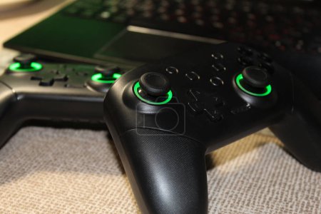 Two joysticks with green backlight. Stock photo of gamepads in high quality. Game concept with friends.