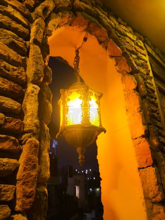 Photo for Old Vintage Lantern glowing in a ancient building with golden light and shadows. Old style lantern backdrop. - Royalty Free Image