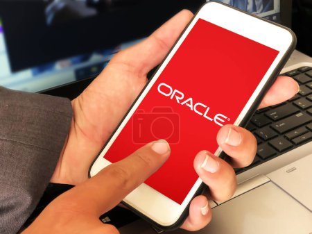 Photo for Database concept background with oracle on mobile screen and man touching the display, editorial backdrop - Royalty Free Image