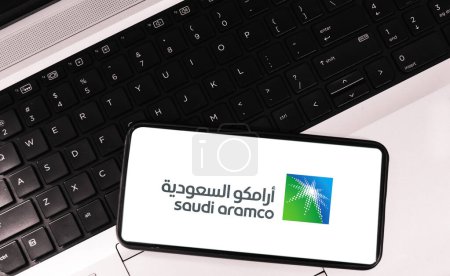 Photo for Editorial saudi oil company aramco background with mobile and laptop - Royalty Free Image