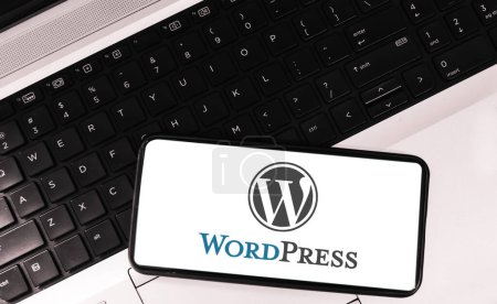 Foto de Wordpress en la pantalla móvil con el ordenador portátil en el fondo, sitio web haciendo fondo editorial herramienta - Imagen libre de derechos