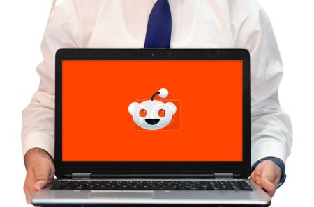 Photo for Reddit on the screen of laptop in orange color with face, editorial tech backdrop. Reddit stock price concept background - Royalty Free Image