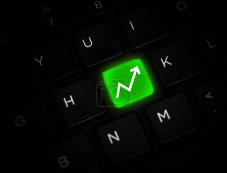 Business Growth Concept Backdrop with Green graph going upward on the keyboard. Arrow pointing towards upside direction, background