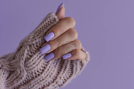 Foto de Uñas de color púrpura. Manicura gelatinosa. Mano de mujer con uñas delicadas de color lavanda de moda - Imagen libre de derechos