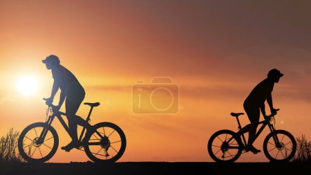 Téléchargez les photos : Silhouette de cyclistes faisant de l'exercice dans la prairie le soir, concept de soins de santé fitness - en image libre de droit