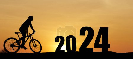 Photo for 2024 welcome,  silhouettes cyclists in the meadow riding bicycles with happiness - Royalty Free Image