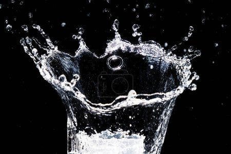 Foto de Salpicando agua sobre un fondo negro. agua salpicadura refrescante fondo negro - Imagen libre de derechos