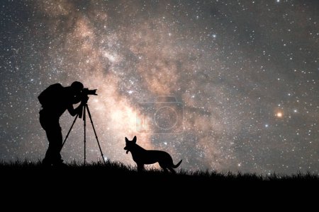 Téléchargez les photos : Homme faisant photo, silhouette d'un chien avec des étoiles sur un fond - en image libre de droit
