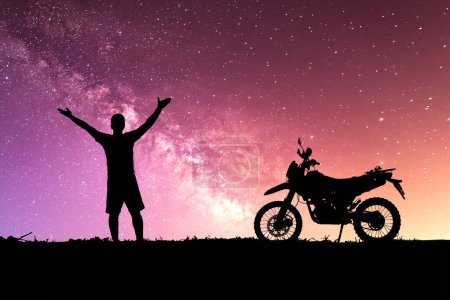 Téléchargez les photos : Homme avec moto-cross contre le ciel étoilé dans le domaine - en image libre de droit