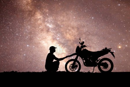 Photo for Man with motocross bike against starry sky in the field - Royalty Free Image