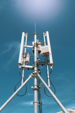 Téléchargez les photos : Tour de communication de téléphone portable sur fond bleu ciel - en image libre de droit