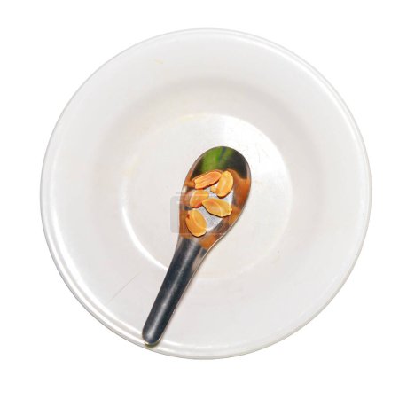 Foto de Pocos frutos secos en cuchara en plato blanco, concepto de crisis alimentaria, escasez de alimentos - Imagen libre de derechos