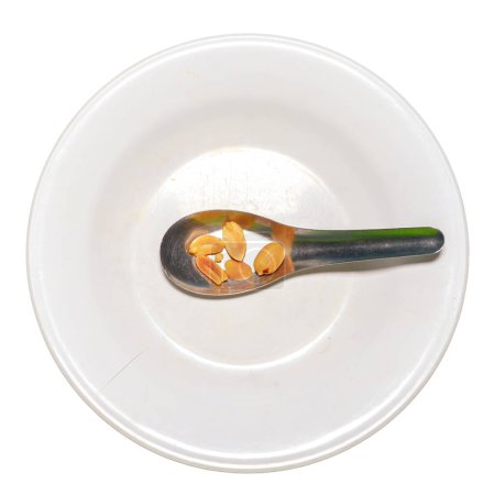 Photo for Few nuts in spoon on white plate, food crisis concept, food shortage - Royalty Free Image