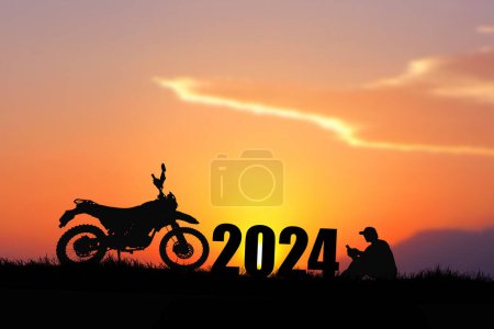 Téléchargez les photos : Silhouette de moto et homme assis près de 2024 signe au coucher du soleil - en image libre de droit