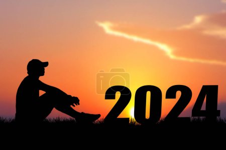 Téléchargez les photos : Silhouette de l'homme assis près 2024 signe au coucher du soleil - en image libre de droit