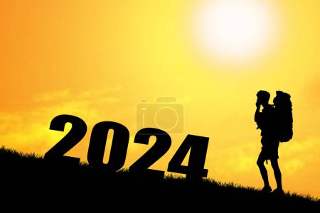 Téléchargez les photos : Silhouette d'homme avec sac à dos debout près de 2024 signe au coucher du soleil - en image libre de droit