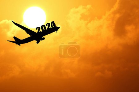Téléchargez les photos : Silhouette de l'avion avec 2024 panneau volant au coucher du soleil - en image libre de droit