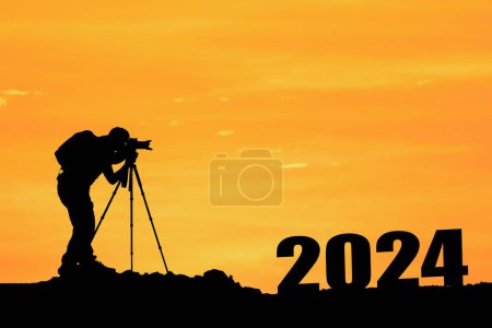 Téléchargez les photos : Silhouette du photographe debout près de 2024 signe au coucher du soleil - en image libre de droit