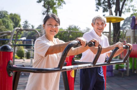 Foto de Asiático senior pareja haciendo ejercicio en gimnasio máquina en parque, concepto para ancianos estilo de vida, al aire libre actividad, entrenamiento, recreación - Imagen libre de derechos
