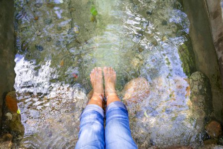 middle aged female feet,foot spa relax in natural hot spring onsen,concept of hot spring,foot health,blood circulation,recreational activities,therapy