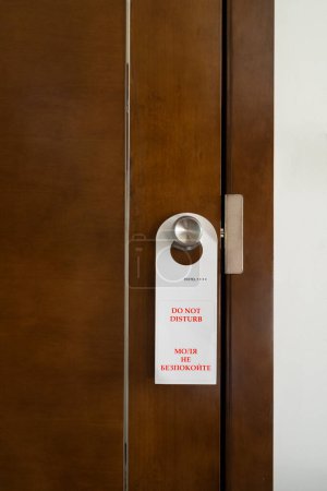 Téléchargez les photos : Le panneau avec l'inscription en anglais et bulgare "ne pas déranger" accroché à la porte d'une chambre d'hôtel - en image libre de droit