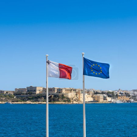 Foto de Las banderas maltesas y europeas ondeando frente al mar - Imagen libre de derechos