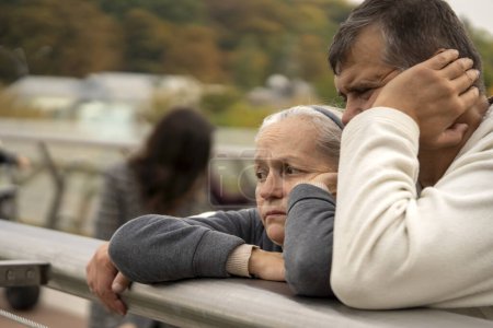 Photo for An elderly couple with sad faces outdoors, a man and a woman in an old age are experiencing a crisis in a relationship or depression, support each other in a difficult life moment. - Royalty Free Image