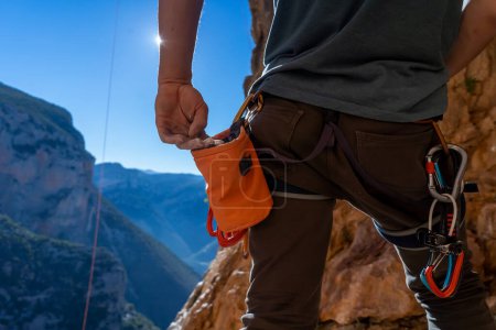 Männliche Hand mit Magnesiapulver in Großaufnahme, vor dem Hintergrund wunderschöner Berge, die Hand eines Bergsteigers, der sich auf das Training im Freien vorbereitet, ein Mann klettert an einem sonnigen Tag in den Twin Caves, Griechenland.