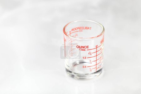 Téléchargez les photos : Tasse de mesure en verre ou tasse doseuse avec mesures d'once affichées. - en image libre de droit