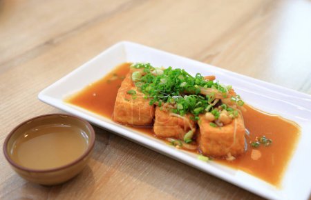 Foto de Filete de tofu de comida fusión japonesa Sirve en plato blanco. - Imagen libre de derechos