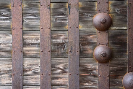 Rusted stake of ancient door lock on old wooden main shrine door.