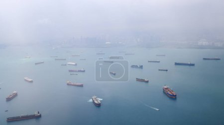 Luftaufnahme der Straße von Singapur, Ozeanliner, Tanker und Frachtschiff mit Regensturm in der Straße von Singapur, Blick aus dem Flugzeug.