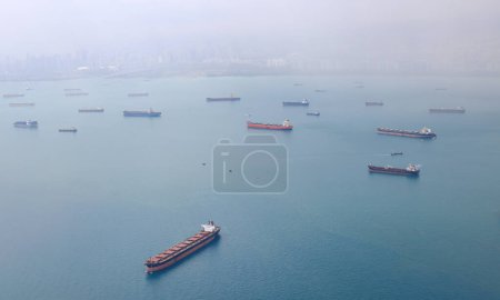 Téléchargez les photos : Vue aérienne du détroit de Singapour, paquebot, pétrolier et cargo avec tempête de pluie dans le détroit de Singapour, Vue de l'avion. - en image libre de droit