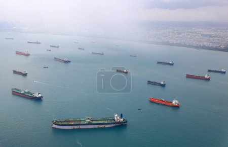 Luftaufnahme der Straße von Singapur, Ozeanliner, Tanker und Frachtschiff mit Regensturm in der Straße von Singapur, Blick aus dem Flugzeug.