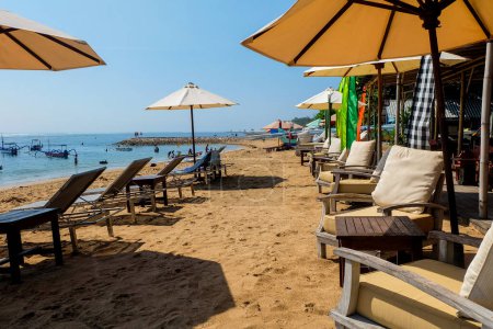 Téléchargez les photos : Chaises vides sur la plage de Sanur, Bali. Des chaises longues. Pas de tourisme. - en image libre de droit