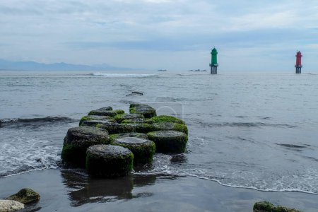 Téléchargez les photos : L'atmosphère le matin à Matahari Terbit Beach, Sanur, Bali, Indonésie. Il y a des vagues qui s'écrasent contre des rochers, des bateaux de pêche et des tours de guet. Le rocher sur lequel reposent les pêcheurs - en image libre de droit