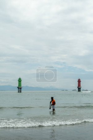 Foto de Un pescador intenta pescar en la costa - Imagen libre de derechos