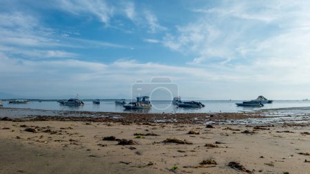 Foto de Tanjung Benoa, Bali, Indonesia (15 de marzo de 2021): La vista sobre la playa de Tanjung Benoa, Bali por la mañana. Los barcos de pesca están listos para navegar para pescar - Imagen libre de derechos