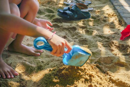 Téléchargez les photos : Un enfant joue dans le sable sur la plage. - en image libre de droit