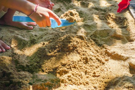 Téléchargez les photos : Un enfant joue dans le sable sur la plage. - en image libre de droit