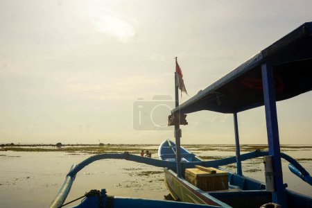 Téléchargez les photos : Bateau de pêche appuyé sur la plage. Bateau de pêche avec drapeau indonésien - en image libre de droit