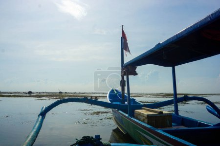 Téléchargez les photos : Bateau de pêche appuyé sur la plage. Bateau de pêche avec drapeau indonésien - en image libre de droit