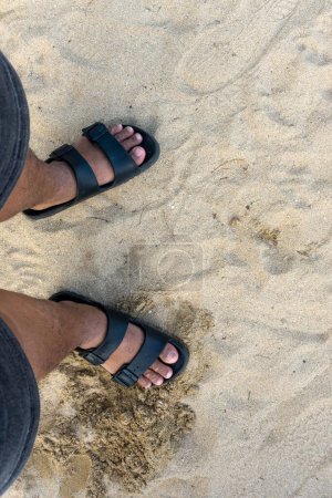 Téléchargez les photos : A pair of male legs on the beach sand - en image libre de droit
