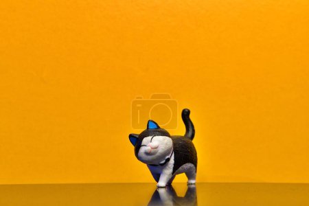 Action-Figur schwarz & weiß Katze isoliert auf gelbem Hintergrund
