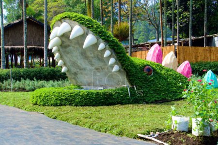 Photo for The crocodile statue is covered with lush and dense grass - Royalty Free Image