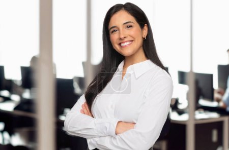 Foto de Retrato de una estudiante de negocios morena en un espacio de oficina de tecnología moderna, sonrisa alegre y exitosa, concepto de trabajo en equipo - Imagen libre de derechos