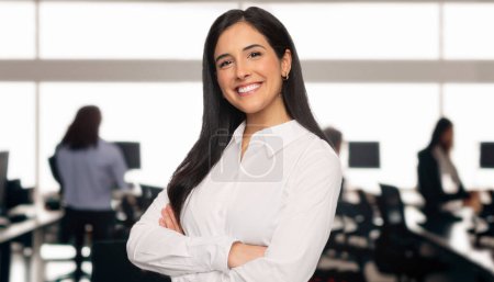 Foto de Portrait of a brunette business student in a modern technology office space, standing with arms folded, teamwork and team success concept - Imagen libre de derechos